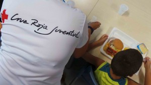 Un menor, durante la comida de la Escuela de Verano de Cruz Roja en Alicante.