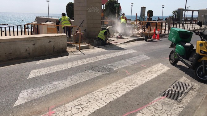 Varios operarios trabajan en las aceras de la calle Virgen del Socorro de Alicante.