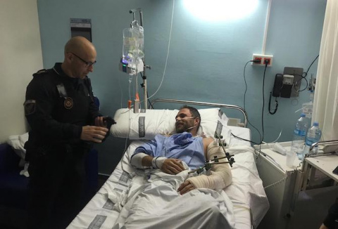 Uno de los agentes de la Polic&iacute;a Local con el hombre herido.