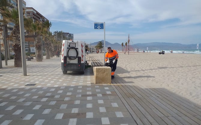 Un operario limpia en la Playa de San Juan tras la celebración de la fiesta de los jóvenes.