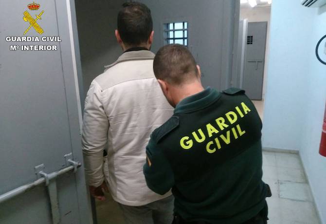 Un agente traslada a un detenido (archivo).